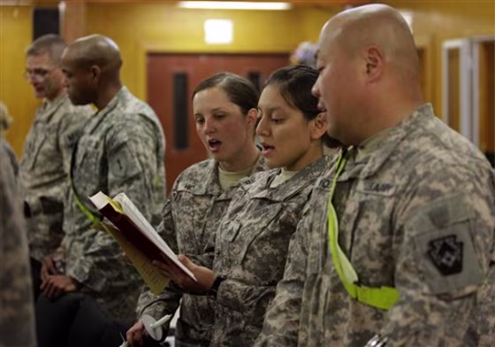 U.S. troops praying during a Christmas Eve mass in a chapel at an American military base in Baghdad, Iraq, Friday, Dec. 24,  2010. (AP Photo/Hadi Mizban)
